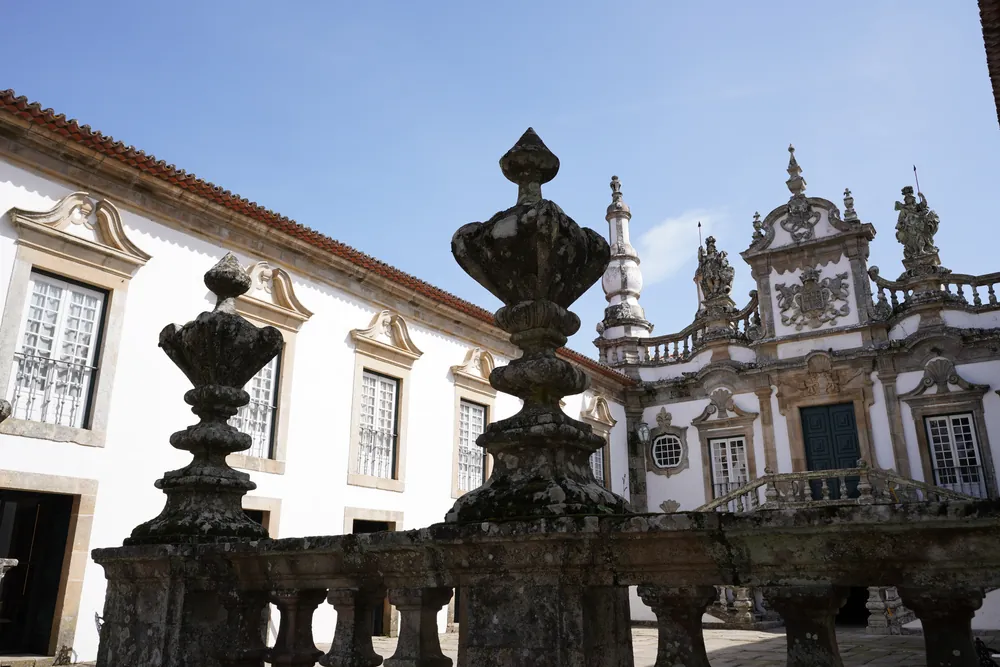 The balustrade that closes the courtyard of honour, with urns on acroteria; behind it, the central wing.