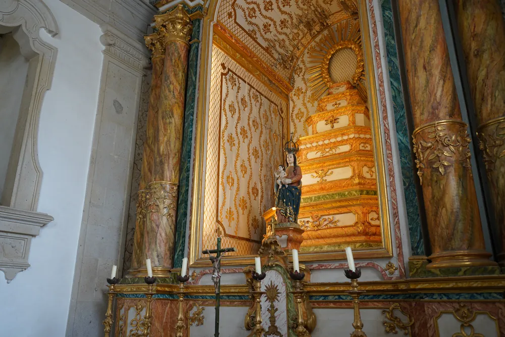 High altarpiece of the chapel: a niche with a stepped eucharistic throne and a gloria, in gilded carving and painted faux marble.