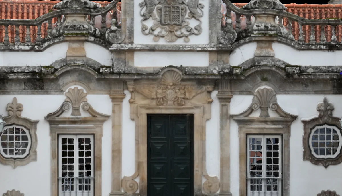 Central wing of the main front: the crest panel with the arms (Álvares, Mourão and Botelho), the undulating balustrade and the door of the main floor. Orthophoto from the survey.